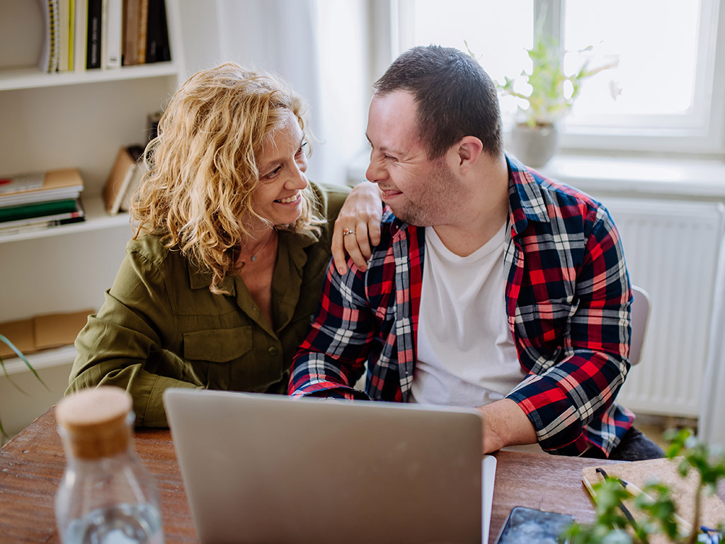 a woman and her son sitting at the kitchen table.